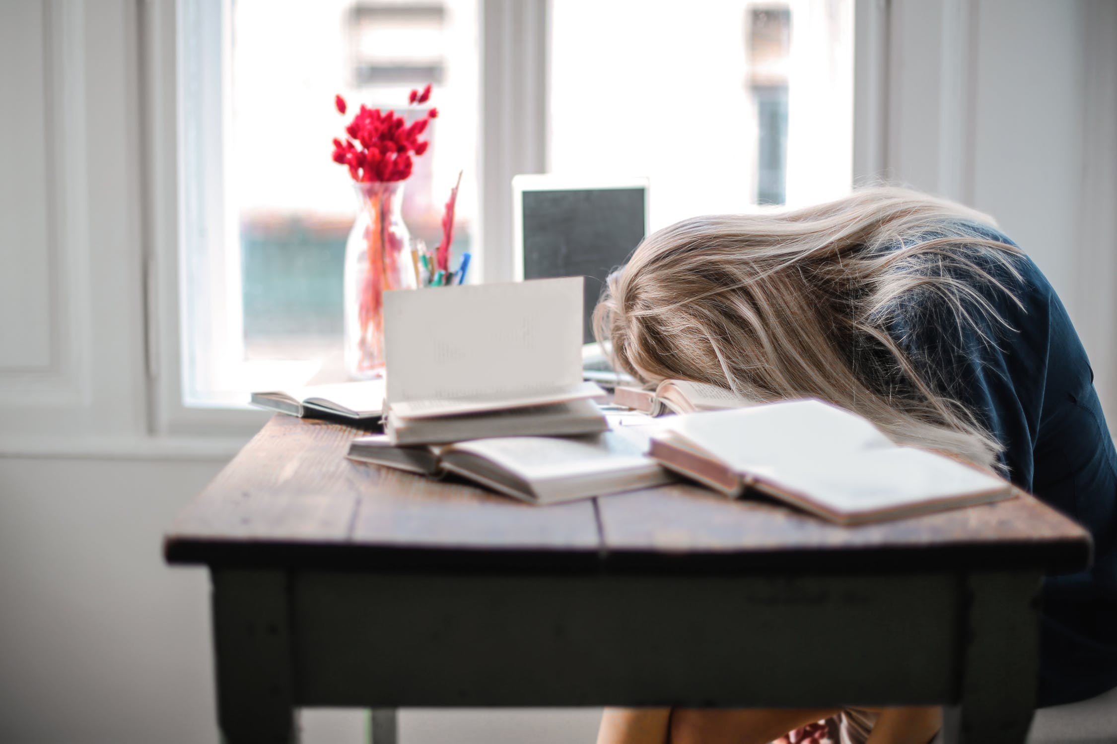 girl studying, her head down on table