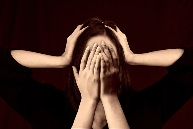 women with both hands covering her face