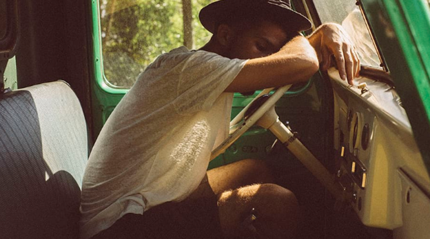 men tired resting against steering wheel