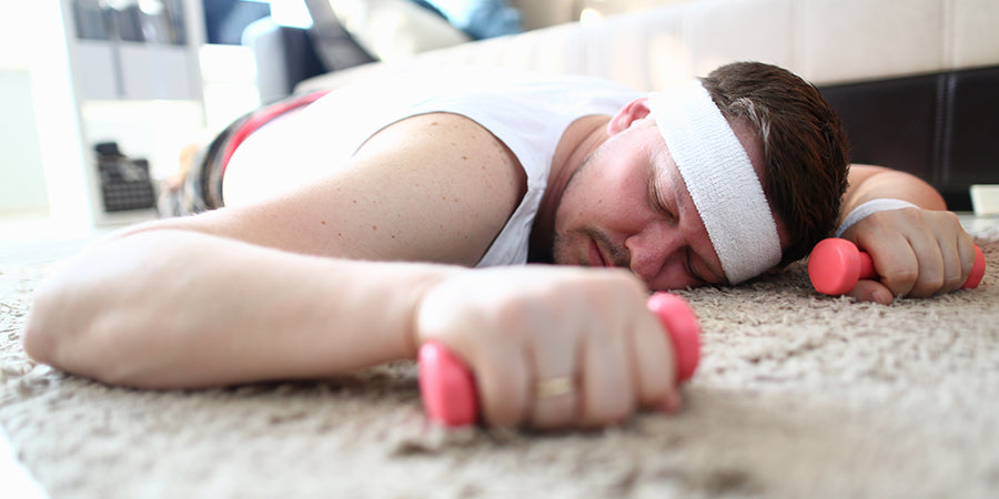 men holding to small dumbbells sleeping on the floor